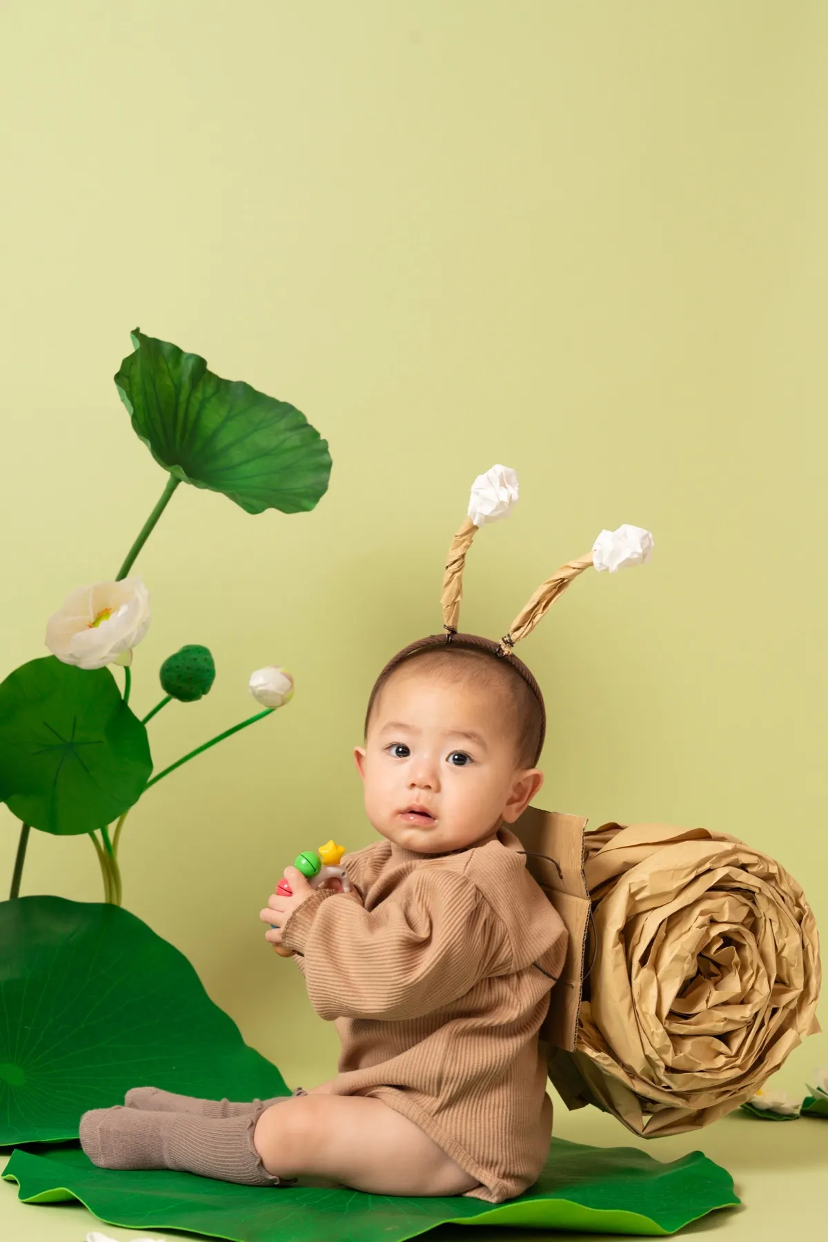グリーンのかたつむりブースで撮影した季節の1歳バースデーフォト